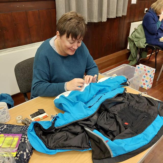 Kate fixing a coat.